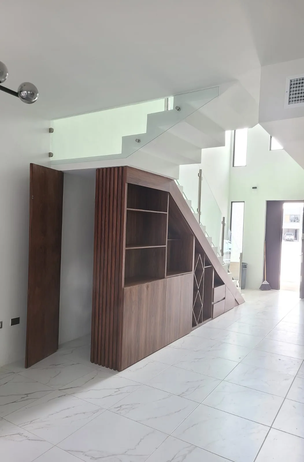 Mueble de carpintería a la medida bajo escalera con entrepaños y detalle de duela